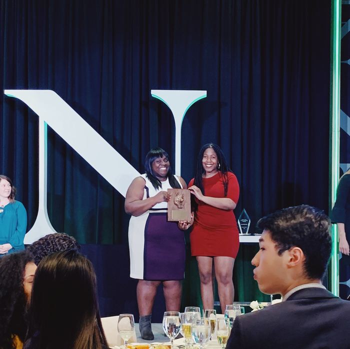 Adebukola Ajao accepting an award on stage at Northeastern University